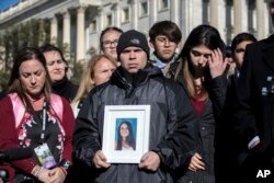 Ilan Alhadeff, joined at left by his wife, Lori, holds a photograph of their daughter, Alyssa Alhadeff, 14, who was killed at Marjory Stoneman Douglas High School in Parkland, Fla., during a rally by lawmakers and student activists in support of gun control.