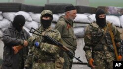 Pro Russian masked armed militants guard barricades near Slovyansk, eastern Ukraine. (April 30, 2014.) 