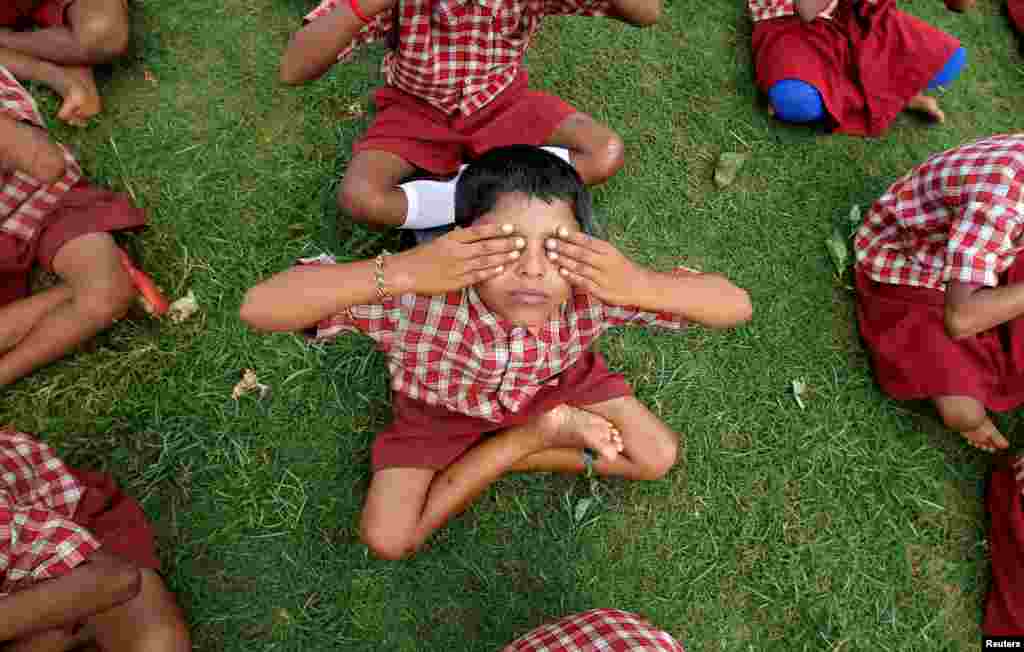 Schoolchildren practice yoga during a training session ahead of World Yoga Day in Agartala, India.