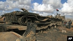 A boot belonging to a soldier loyal to Libyan leader Moammar Gaddafi on a destroyed tank after an air strike by coalition forces, along a road between Benghazi and Ajdabiyah March 21, 2011
