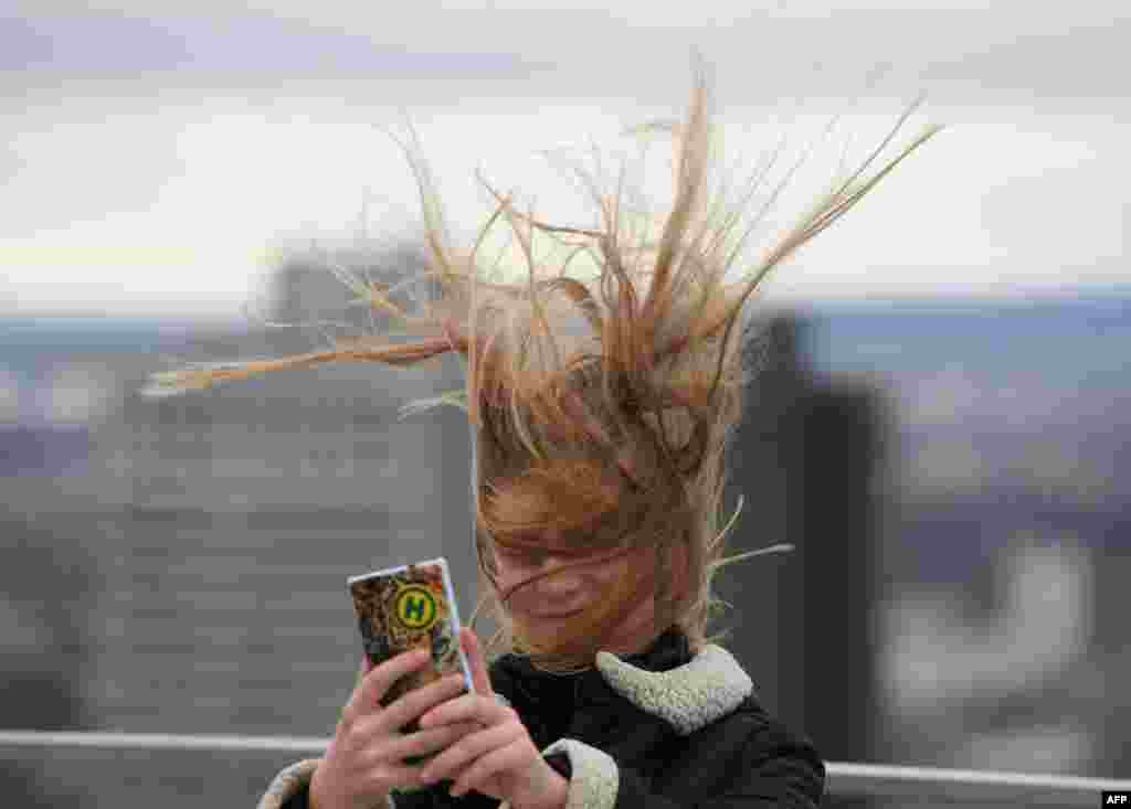 Elena, from Dresden, takes a selfie, with her hair ruffled by the wind as she stands on a visitors' platform on the Maintower in Frankfurt am Main, Germany, during stormy weather.