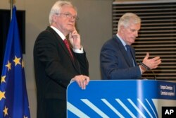 FILE - David Davis, left, British secretary of state for exiting the European Union, and European Union chief Brexit negotiator Michel Barnier participate in a media conference at EU headquarters in Brussels, Oct. 12, 2017.