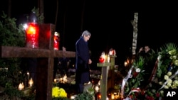 U.S. Secretary of State John Kerry pays his respects as he visits the grave of Tadeusz Mazowiecki, Poland's first democratically elected non-communist Prime Minister, in Laski, Poland, Nov. 4, 2013.