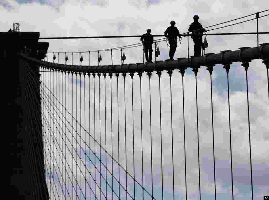 New York City police officers, including members of the Emergency Services Unit, walk down a cable on the Brooklyn Bridge during a training exercise in New York.