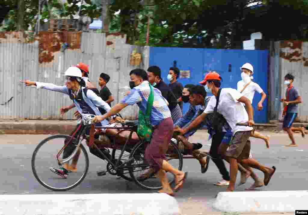 People carry a person who was shot during a security force crackdown on anti-coup protesters in Thingangyun, Yangon, Myanmar.