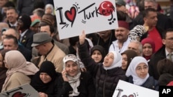 Crowd members hold signs showing support for Turkish President Recep Tayyip Erdogan at the inauguration of the Diyanet Center of America in Lanham, Maryland, April 2, 2016.