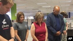 Employees in the Clarion Ledger newsroom in Jackson, Miss., observe a moment of silence, July 5, 2018, to honor five people shot to death a week earlier at the Capital Gazette in Annapolis, Md. Pictured are editorial cartoonist Marshall Ramsey, reporter Sarah Fowler, editor Barbara Gauntt, reporter Jimmie Gates and editor Tammy Ramsdell.