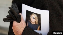 FILE - A man holds a sign honoring Sunday Times journalist Marie Colvin after a memorial service, outside St Martin in the Field in London, May 16, 2012.