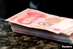 FILE - Chinese 100 yuan banknotes are seen on a counter of a branch of a commercial bank in Beijing, China.