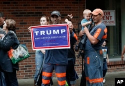 FILE - Coal miner Chris Steele holds a sign supporting Donald Trump outside a Democratic presidential candidate Hillary Clinton event in Williamson, W.V., May 2, 2016.