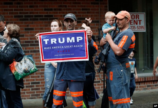 FILE - Coal miner Chris Steele holds a sign supporting Donald Trump outside a Democratic presidential candidate Hillary Clinton event in Williamson, W.V., May 2, 2016.