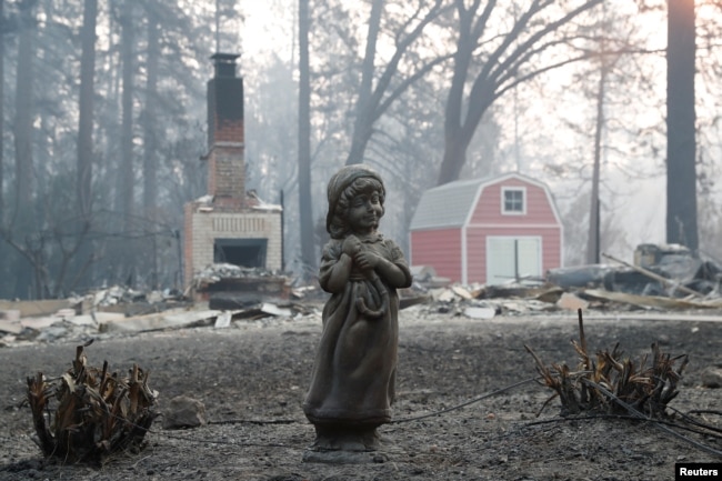 Una estatua delante de una casa destruida por el incendio Camp en Paradise, California. Nov. 17 de 2018.