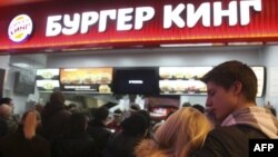 FILE - A young Russian couple waits in line on the opening day at Russia's first Burger King fast food restaurant in Moscow on January 21, 2010. (AFP PHOTO / ANDREY SMIRNOV)