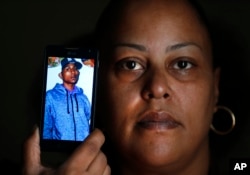 Rebecca O'Hara holds a phone showing a photo of her 25-year-old transgender son Ashton O'Hara, who was killed in July 2015, in Detroit, Nov. 11, 2015.