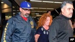 Tonya Couch, center, is taken by authorities after arriving at Los Angeles International Airport, Thursday, Dec. 31, 2015, in Los Angeles. Authorities said she and her son, Texas teenager Ethan Couch, who was sentenced to probation after using an "affluenza" defense for a 2013 wreck in Texas, fled to Mexico together in November (AP Photo/Mark J. Terrill)