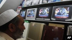 A man watches Pakistan's Prime Minister Yusuf Raza Gilani on a televised address to the parliament at an appliance store in Islamabad on May 9, 2011.