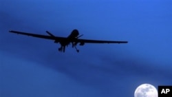 FILE - A U.S. Predator drone flies over the moon above Kandahar Air Field, southern Afghanistan. 