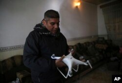 FILE - Iraqi special forces Lt. Col. Ali Hussein holds a destroyed drone used by Islamic State militants, which was shot down by his brigade, in the Bakr front line neighborhood, in Mosul, Iraq, Nov. 25, 2016.