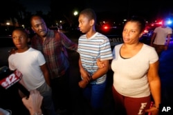 Max Charles, second from right, 14, a student at Marjory Stoneman Douglas High School in Parkland, Fla., speaks to members of the media after being picked up by family members at a nearby hotel, Feb. 14, 2018, in Coral Springs, Fla.