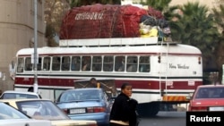 FILE: An overloaded bus makes its way to Zimbabwe with cross-border shoppers from Johannesburg in this July 25, 2006 file photo. 