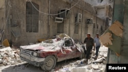 Un vehículo destruido en una calle de al-Qaterji, un vecindario de la asediada ciudad de Alepo en Siria, luego de un ataque aéreo el domingo. Octubre 17, 2016. 