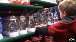 Snowman snow globes that light up are a favorite for one young shopper. (E.Celeste/VOA)