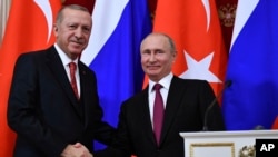 FILE - Russian President Vladimir Putin, right, shakes hands with Turkey's President Recep Tayyip Erdogan after their joint news conference following the talks in the Kremlin in Moscow, Russia, Jan. 23, 2019. 