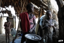 FILE - South Sudanese children fleeing from recent fighting in Lasu in South Sudan stand in a church after crossing the border into the Democratic Republic of Congo, near Aba, Dec. 23, 2017.