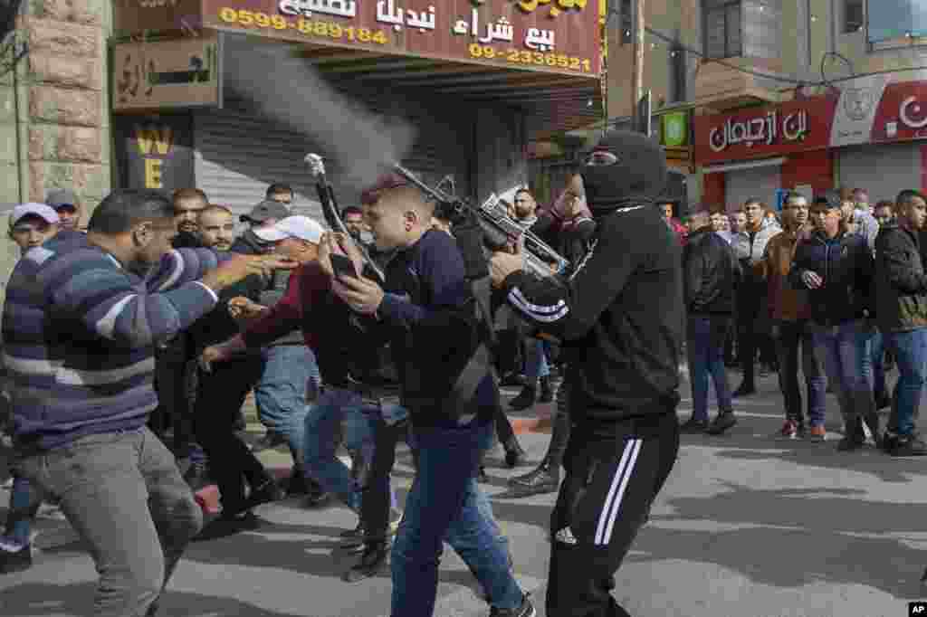 A Palestinian gunman fires into the air during scuffles between Palestinian security forces and local militants during the funeral procession of Jamil Kayyal, 31, who was killed in clashes with Israeli forces, in the West Bank city of Nablus.