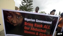 FILE - Members of Bring Back Our Girls movement carry a banner to press for the release of the missing Chibok schoolgirls in Lagos, April 14, 2016.