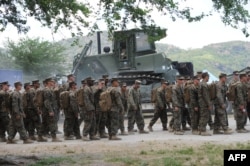 FILE - US marines prepare to board buses outside their temporary base on their way to a nearby air base as the annual US-Philippine joint military exercise winds down at the former US target range in Crow Valley, Capas town, north of Manila on May 15, 2014.