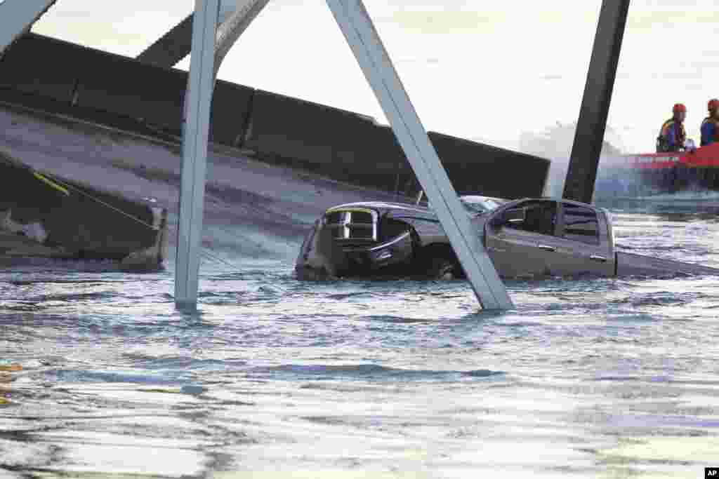 A damaged truck sits in the water on a portion of the Interstate-5 bridge that is submerged after it collapsed into the Skagit river dumping vehicles and people into the water in Mount Vernon, Wash., May 23, 2013.