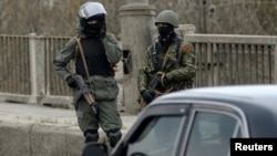 FILE - Pro-Russia armed men stand at an improvised checkpoint in Slovyansk, eastern Ukraine, April 12, 2014.