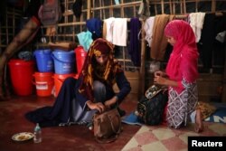 Formin Akter packs her bag next to her friend Shahima before heading to Chittagong, Bangladesh, Aug. 24, 2018.
