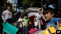 Anak-anak pengungsi membawa mainan dan tas di Lapangan Victoria di Athena, Yunani (1/10). 