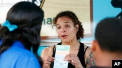 FILE - Jessica Jones, center, speaks to people about Amendment 4 at Charles Hadley Park in Miami, Oct. 22, 2018. Amendment 4 asked voters to restore the voting rights of people with past felony convictions, and Floridians approved it on Nov. 6, 2018. 