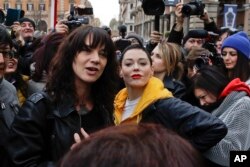 Actresses Asia Argento, left, and Rose McGowan pose during a demonstration to mark International Women's Day in Rome, March 8, 2018. Asia Argento, an Italian actress who helped launch the #MeToo movement, is launching a new movement, #WeToo, which aims to unite women against the power imbalance in favor of men.