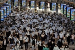 FILE PHOTO: Commuters wearing face masks arrive at Shinagawa Station at the start of the working day amid the coronavirus disease (COVID-19) outbreak, in Tokyo, Japan, August 2, 2021 .REUTERS/Kevin Coombs/File Photo