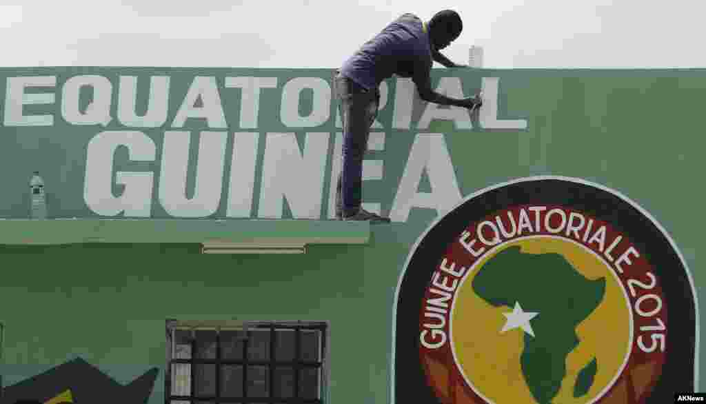 Un traveilleur passe un coup de peinturw sur le haut du mur avant l&#39;ouverture de la&nbsp;Coupe d&#39;Afrique des Nations&nbsp;samedi au stade de Bata, en Guinée équatoriale, le vendredi 16 janvier 2015.