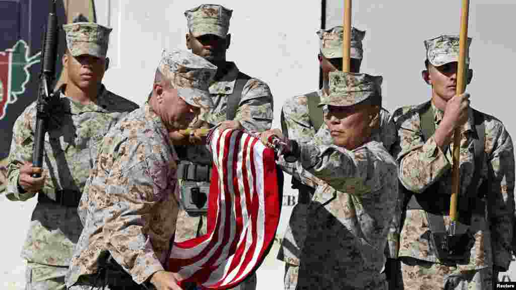 U.S. Marines stand at attention during a handover ceremony, as the last U.S. Marines unit and British combat troops end their Afghan operations, in Helmand province, Oct. 26, 2014. 