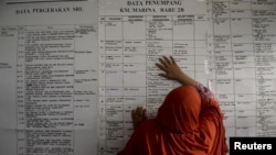 Một phụ nữ tìm kiếm thông tin về thành viên gia đình trên chiếc phà bị chìm Sulawesi, Indonesia, ngày 21/9/2015.