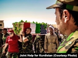 FILE - People carry the coffin of American volunteer Leland Scott during burial ceremony in Sharfadin shrine, Duhok, Iraq, June 21, 2016.