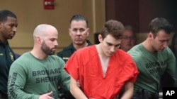 Nikolas Cruz est conduit dans la salle d'audience avant du palais de justice du comté de Broward à Fort Lauderdale, en Floride, le 14 mars 2018. 