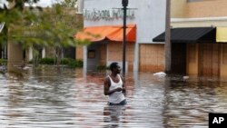 John Duke wades through a flooded street to try to salvage his flooded car in the wake Hurricane Irma, Sept. 11, 2017, in Jacksonville, Fla.