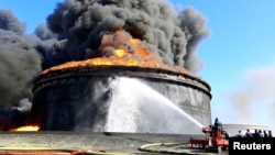 Firefighters trained hoses on a flaming oil storage tank in Es Sider a month ago. The fire began when militias in attack vessels fired rockets at the storage facility.