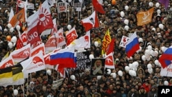 Demonstrators hold Russian opposition flags during a rally protesting against election fraud in Moscow, Saturday, Dec. 24, 2011.