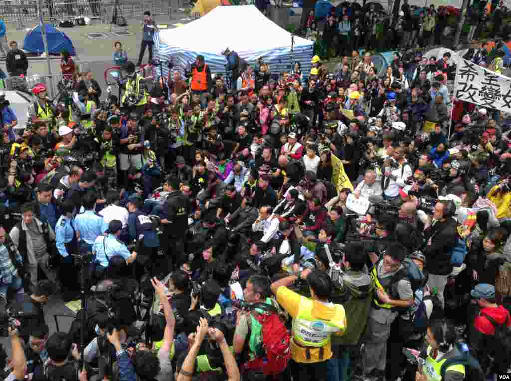 Agentes da polícia tentam removem a multidão de manifestantes das áreas ocupadas de Hong Kong, Dez. 11, 2014. (Hai Yan/VOA)