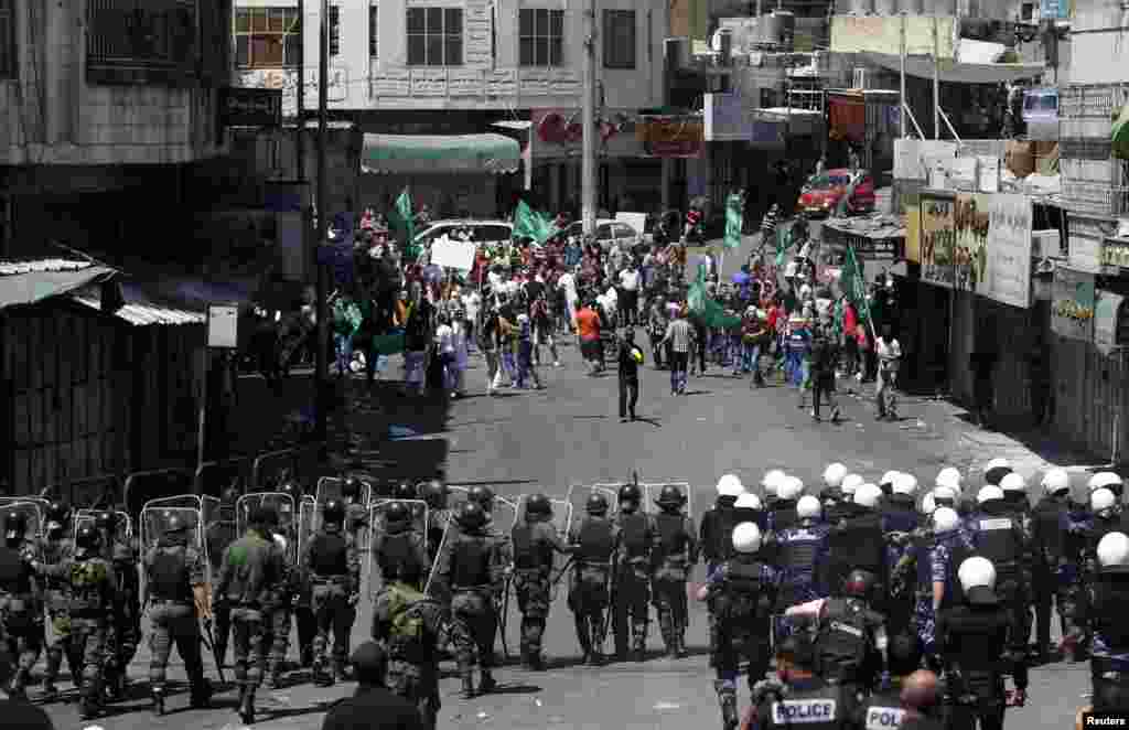 Members of Palestinian security forces try to stop the Palestinian protesters from clashing with Israeli troops during a demonstration against the Israeli offensive in Gaza, in the West Bank city of Hebron, Aug. 22, 2014. 