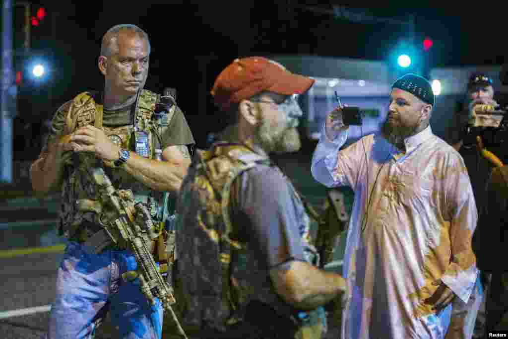 Members of the Oath Keepers patrol the streets with their personal weapons during protests in Ferguson, Aug. 11, 2015.