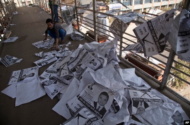 A Bangladeshi man collects election posters in Dhaka, Bangladesh, Monday, Dec. 31, 2018.